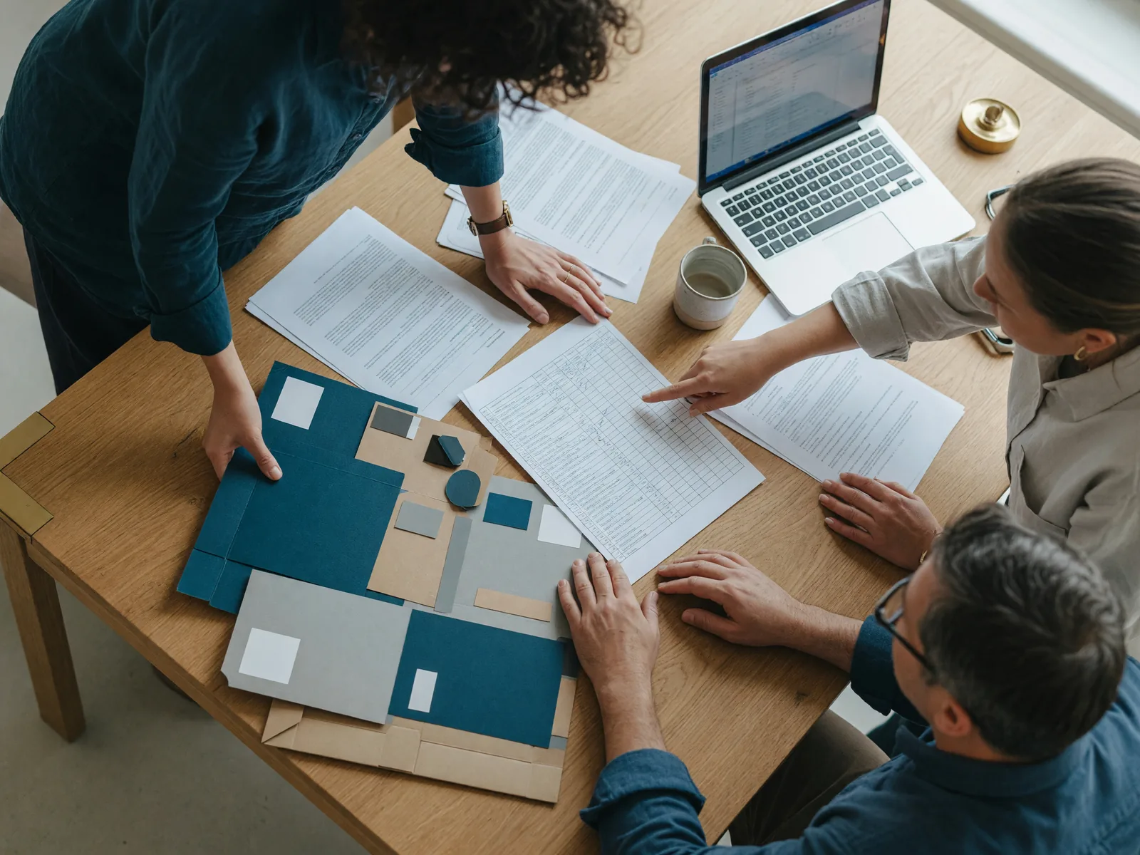 A team reviewing documents and packaging samples at a wooden table